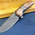 Woox Knife Salve Leggenda sitting against a wood and blue backdrop