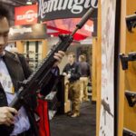 Photo of a person inspecting a rifle at what looks like a gun show