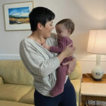 Tatiana Whitlock holding her baby in a living room setting