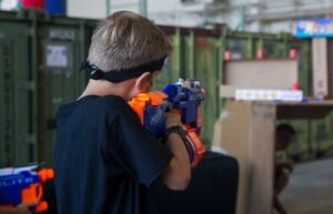 Kid aiming a nerf rifle at a target